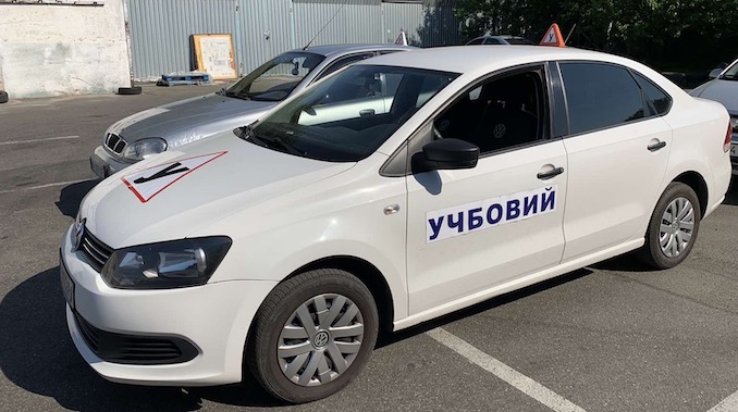 Учень на уроці в автошколі з інструктором