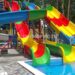Дитячий водний атракціон: ігровий комплекс з гірками для дітей на сонячному майданчику