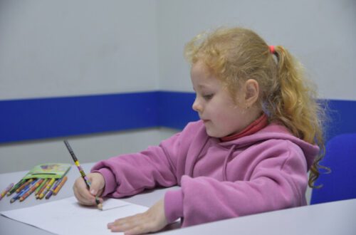 Дитина навчається писати в рядку за шкільною партою